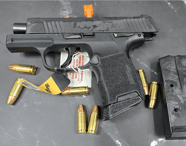 Handgun with ammunition on dark surface